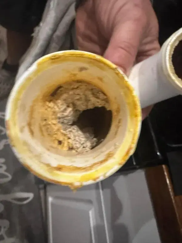Drain pipe partly blocked by hardened grease buildup