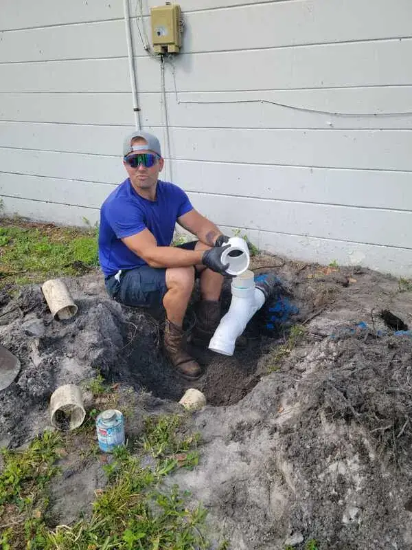 Michael from Crowebird Plumbing working on an underground plumbing repair in a customer's yard